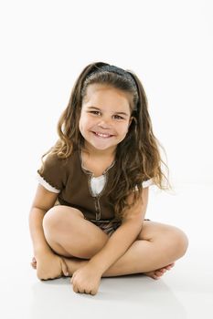 Cute little latino girl sitting looking at viewer smiling.