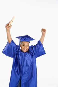 Young boy wearing blue graduation gown holding diploma and cheering.