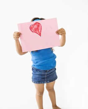 Young girl showing off drawing of heart.