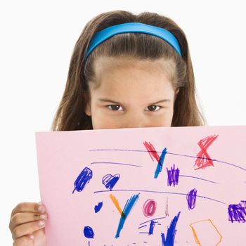 Young girl holding drawing over mouth..