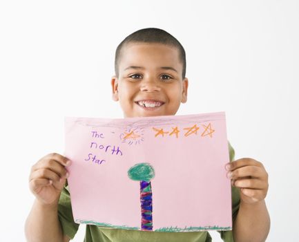 Young boy proudly showing drawing.