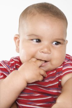 Close-up of cute little hispanic baby boy with fingers in mouth.