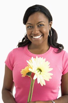 Portrait of smiling African American female standing holding flowers.