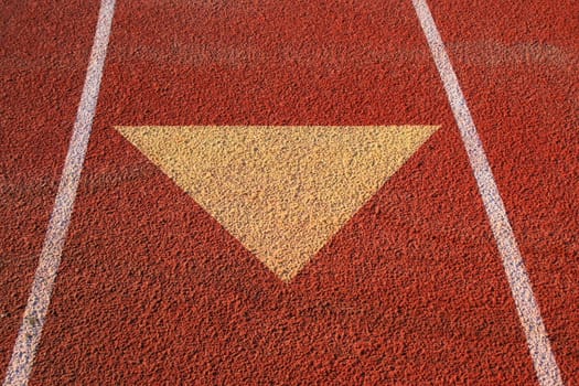 Close up of an arrow on a running lane.
