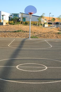 Basketball court on a sunny day in a park.
