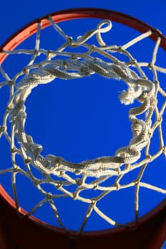 Basketball net over clear blue sky.
