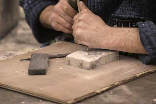 man is working with his hand on a piece of marble