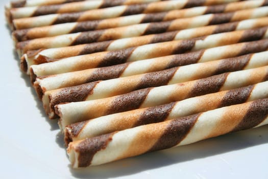 Close up of chocolate cookie sticks on a plate.
