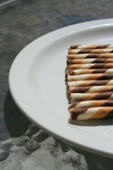 Close up of chocolate cookie sticks on a plate.
