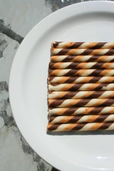 Close up of chocolate cookie sticks on a plate.
