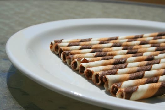 Close up of chocolate cookie sticks on a plate.
