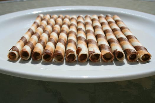 Close up of chocolate cookie sticks on a plate.
