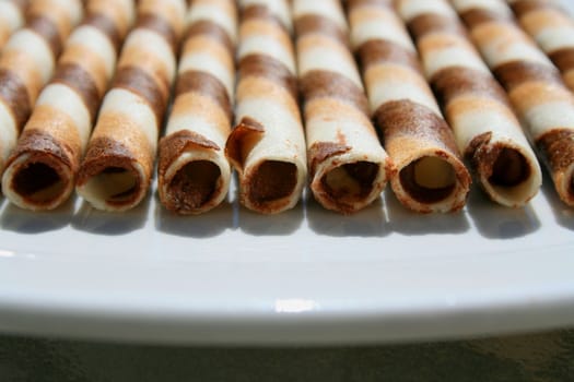 Close up of chocolate cookie sticks on a plate.
