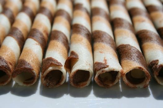 Close up of chocolate cookie sticks on a plate.
