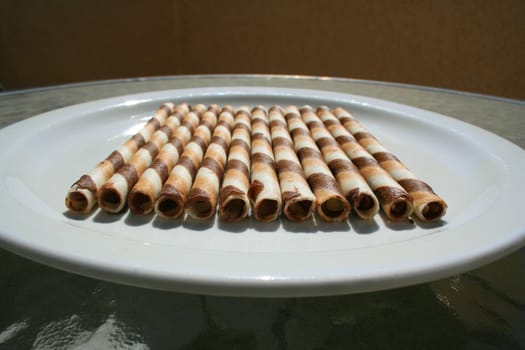 Close up of chocolate cookie sticks on a plate.
