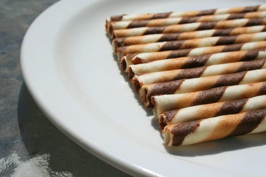 Close up of chocolate cookie sticks on a plate.
