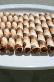 Close up of chocolate cookie sticks on a plate.
