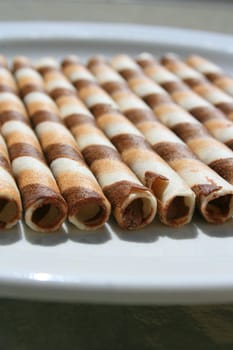 Close up of chocolate cookie sticks on a plate.
