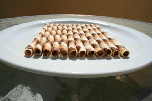 Close up of chocolate cookie sticks on a plate.
