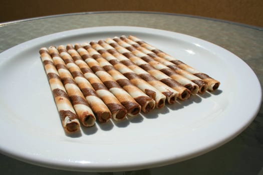 Close up of chocolate cookie sticks on a plate.
