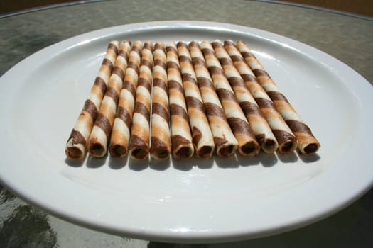 Close up of chocolate cookie sticks on a plate.
