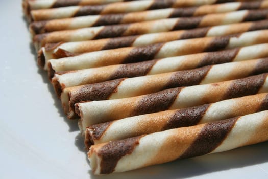 Close up of chocolate cookie sticks on a plate.
