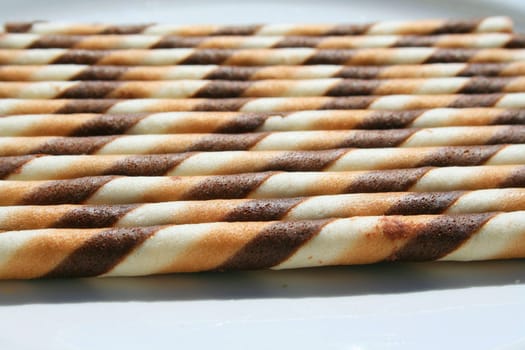 Close up of chocolate cookie sticks on a plate.
