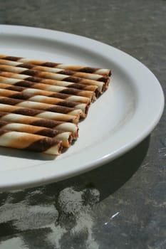 Close up of chocolate cookie sticks on a plate.

