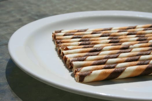 Close up of chocolate cookie sticks on a plate.
