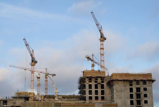 Cranes and building on a background sky