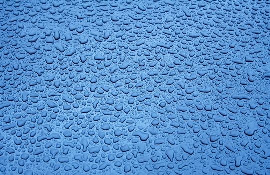 Water Droplets on a Blue Steel Surface. Close-up