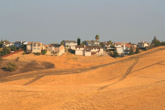 A group of houses on a hilltop.
