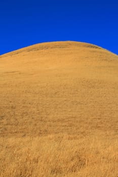 Tall mountain on a sunny day over blue sky.
