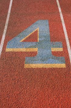 Close up of a number four on a running lane.
