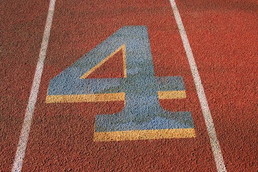 Close up of a number four on a running lane.
