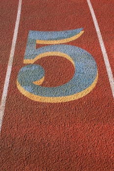 Close up of a number five on a running lane.
