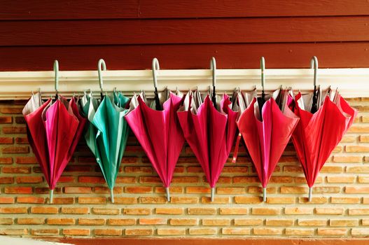 Pattern of umbrella hang on cement and wood wall