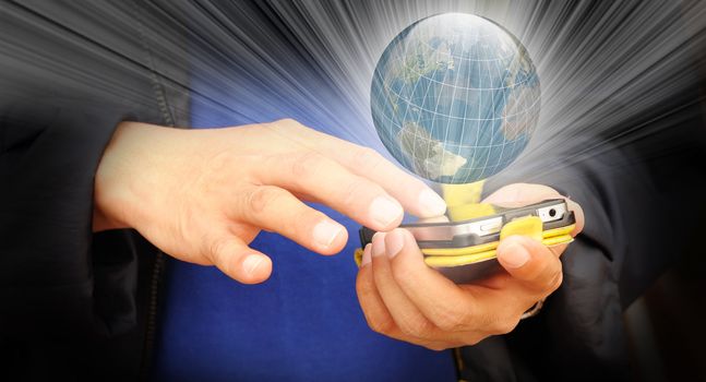 Hand of business man touch screen of mobile phone with ray of light shining through earth globe