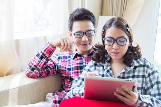 Couples with a tablet computer in living room