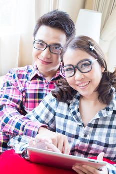 Couples with a tablet computer in living room