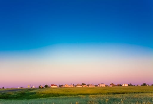 farm houses on the field at sunset