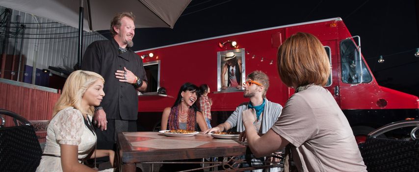 Hipster and friends talking with chef at canteen diner