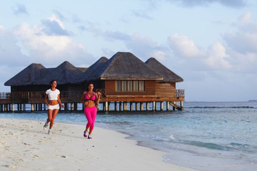 Fitness sport women running on beach in morning