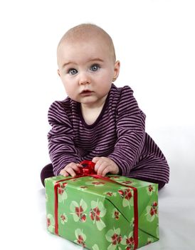 young child holding huge present and looking towards the camera