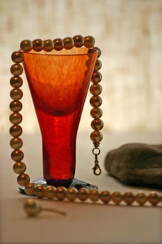 Red vase with gold pearl beads and stones.