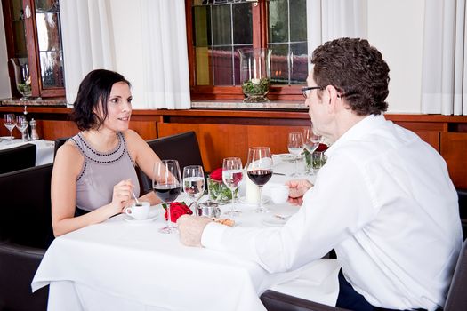 happy smiling couple in restaurant for dinner sitting talking drinking