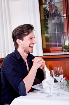 happy smiling couple in restaurant for dinner sitting talking drinking