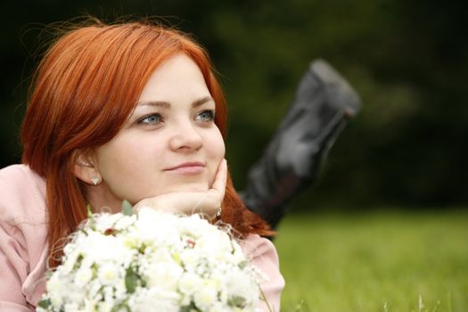 The nice girl with a bouquet in a grass
