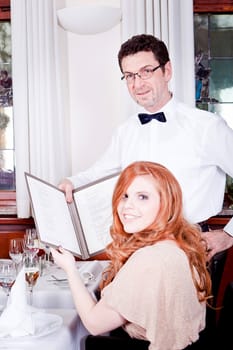 man and woman in restaurant waiter bring card and order food