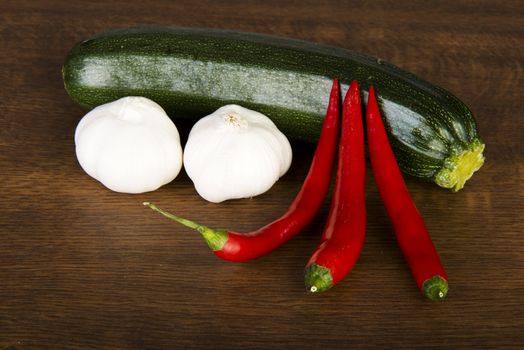 Zucchini, garlik and red hot chilie peppers on kitchen table